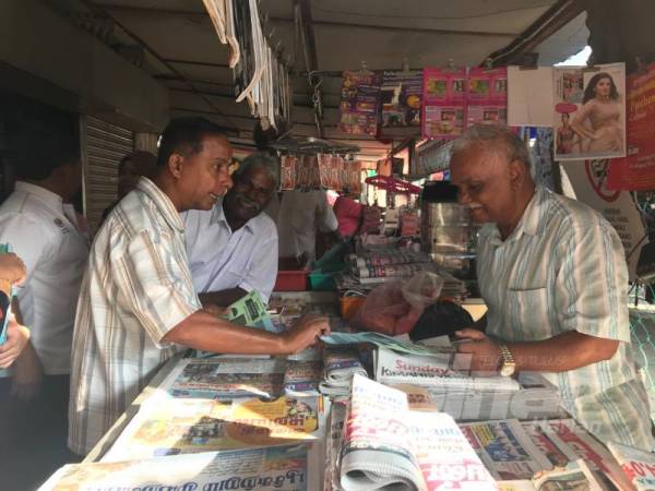 Kula Segaran (kiri) menerangkan faedah mencarum SKSPS kepada peniaga Pasar Buntong.