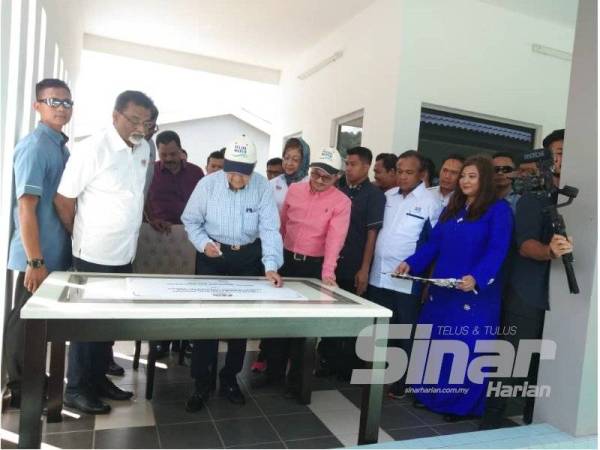 Dr Mahathir menandatangan plak perasmian Loji Rawatan Kumbahan Pantai Tengah di sini hari ini.