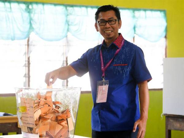 Calon BN, Datuk Mohamad Alamin ketika mengundi di Sekolah Kebangsaan Our Lady of Fatima (M) Kelatuan kelmarin. - Foto: BERNAMA