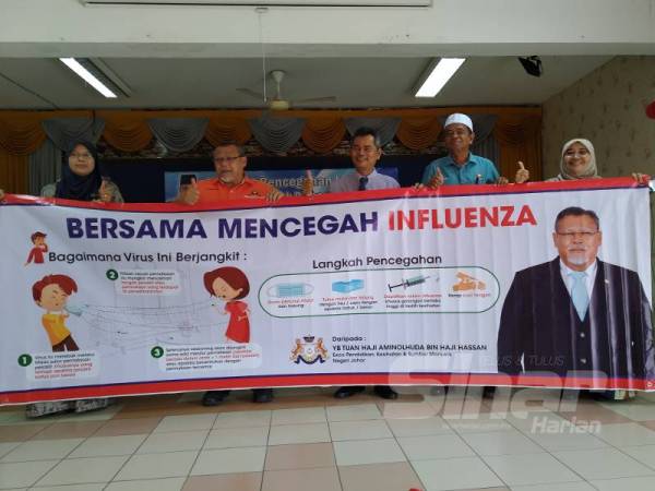 Aminolhuda ( dua dari kiri) menyerahkan kain rentang kempen pencegahan Influenza kepada sekolah- sekolah Johor Bahru di SK Taman Damai Jaya.
