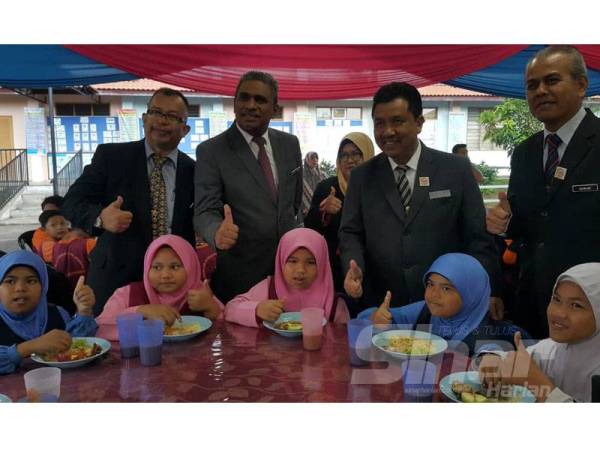 Salim (dua dari kanan) menunjukkan isyarat bagus selepas meninjau hari pertama pelaksanaan penambahabaikan program RMT di SK Jerong, di sini hari ini.