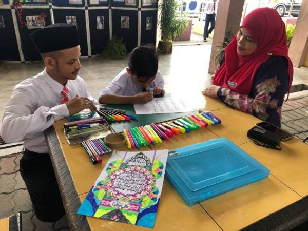 Ahmad Danish Aqil (tengah) yang dilihat mudah sahaja menghasilkan tulisan seni khat sambil ditemani Fakhrul Azizi (kiri) dan gurunya, Nashimah Zakaria.