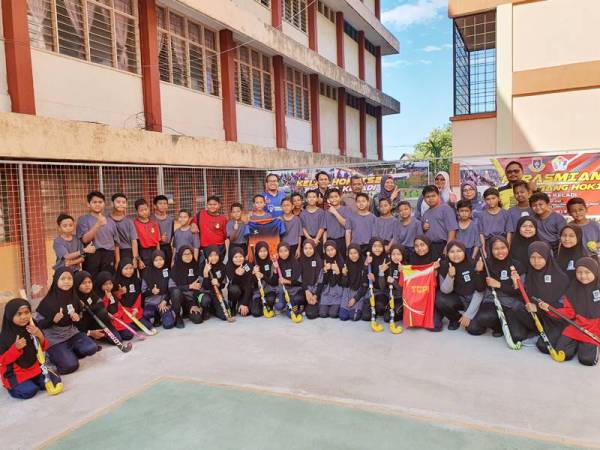 Ahli Kelab Hoki TS25 SK Paya Keladi bergambar bersama pemain hoki kebangsaan, Mohamad Sukri Abdul Mutalip kelmarin.