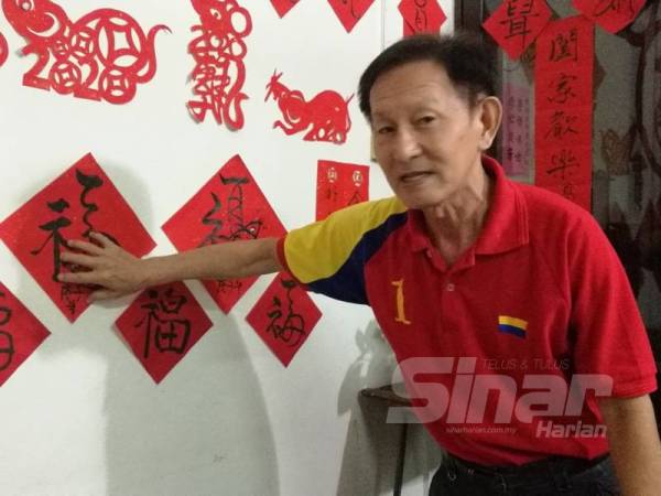 Choon Aun menunjukkan hasil seni kaligrafi yang ditampal di dinding rumahnya.