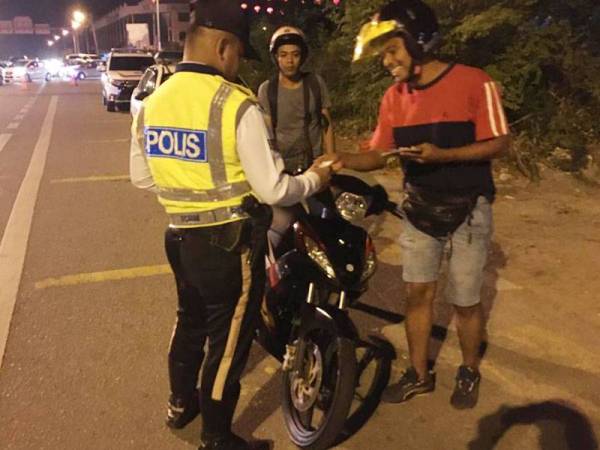 Anggota polis memeriksa salah sebuah motosikal dalam Op Tahun Baru Cina 2020 semalam.