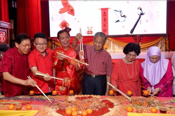 Dr Mahathir (tiga dari kanan) dan isteri Tun Dr Siti Hasmah Mohamad Ali (dua dari kanan) serta Dr Wan Azizah (kanan) menggaul ‘Yee Sang’ semasa hadir pada Majlis Rumah Terbuka Tahun Baru Cina 2020 anjuran Dewan Perhimpunan China Kuala Lumpur dan Selangor hari ini.  - Foto: Bernama