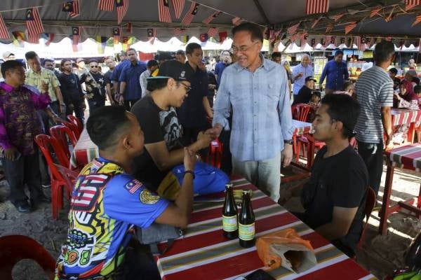 Anwar beramah mesra dengan pengunjung pada Program Tinjauan Mesra di Telok Kemang hari ini. - Foto: Bernama
