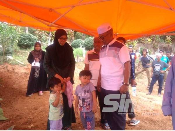 Ismail (kanan) menyampaikan kata-kata semangat kepada Nurul Azmira ketika ditemui di tapak perkuburan terbabit.