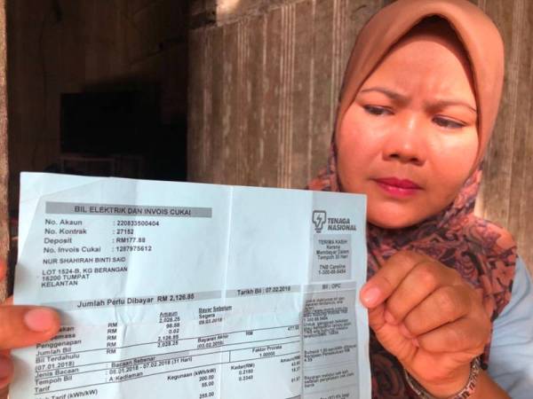 Dahalia menunjukkan bil elektrik dengan jumlah tunggakan RM2,126.85 yang tidak mampu untuk dijelaskan.