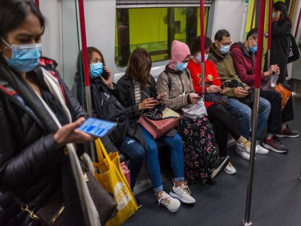 Kebanyakan bandar di China kini mewajibkan kesemua penduduk mereka memakai topeng muka di tempat awam sebagai langkah mencegah penularan koronavirus tersebut. - Foto AFP