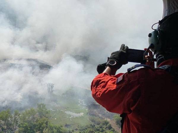 Anggota bomba merakam situasi terkini lokasi tapak pelupusan sampah dari pandangan udara. -Foto JBPM Kedah