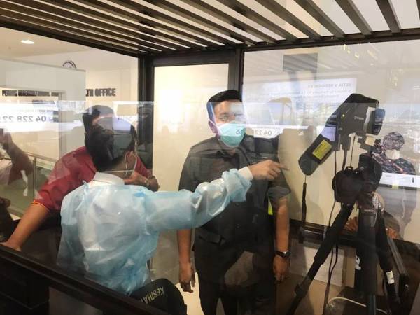 Afif diberi penerangan oleh pgawai JKN Pulau Pinang mengenai ujian saringan yang dijalankan terhadap pelancong di LTAPP.