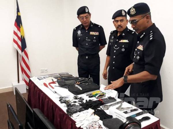 Mohd Rozi (kanan) menunjukkan barang yang dirampas daripada kumpulan Pon Maheran.