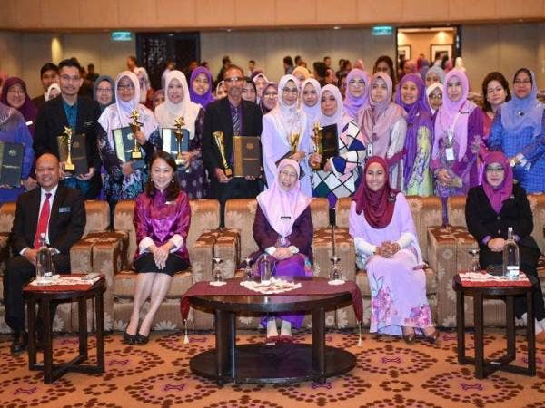 Dr Wan Azizah (duduk, tengah) bersama warga kerja Kementeriannya pada Perhimpunan Bulanan KPWKM hari ini. - Foto Bernama
