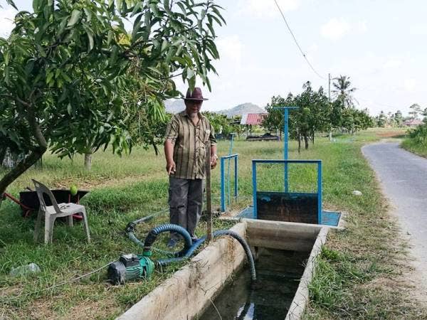 Zainol menunjukkan bekalan air telaga yang digunakan sebagai sumber air di ladangnya.
