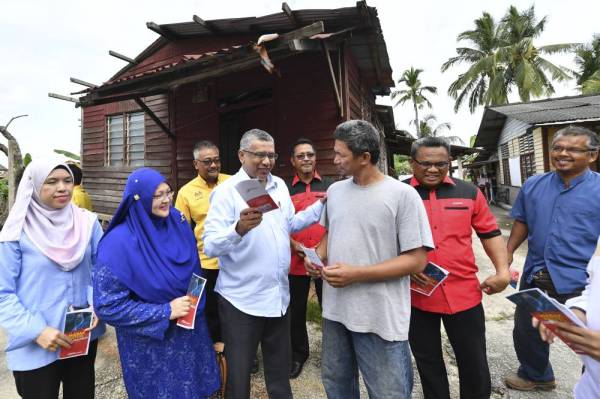 Mohamed Hanipa Maidin (lima dari kanan) beramah mesra dengan penduduk sambil menyalurkan maklumat mengenai jangkitan koronavirus. -Foto Bernama