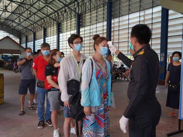 Pihak berkuasa Thailand memeriksa kesihatan pelancong dalam usaha mengekang penularan koronavirus. - Foto Bangkok Post