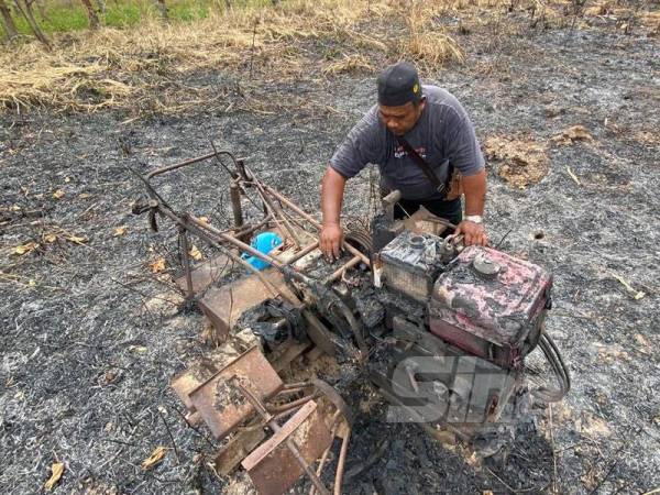 Jaafar melihat jentera membajaknya yang musnah akibat kebakaran di ladang tebunya.
