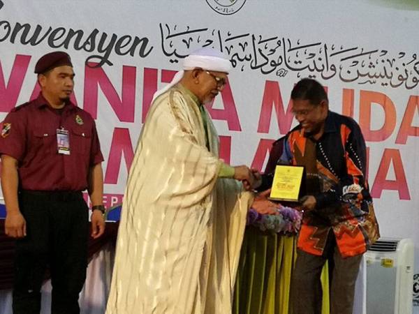 Abdul Hadi (dua dari kiri) menerima cenderahati daripada Hanafiah pada program Diskusi Tokoh Bicara 'Demi Perpaduan' sempena Konvensyen Wanita Muda Se-Malaysia di Stadium Negeri, Kuala Terengganu hari ini.