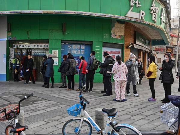 Penduduk beratur panjang di farmasi di Wuhan untuk mendapatkan bekalan ubat-ubatan. - AFP