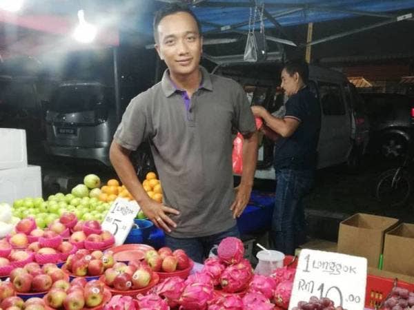 Yobi Folendra meniaga buah-buahan di pasar malam sekitar Ipoh.