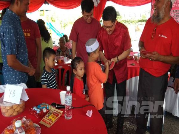 Kah Woh turut menyampaikan angpau kepada kanak-kanak yang hadir pada majlis tersebut.