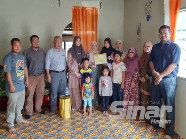 Tarmizi (tiga dari kiri) menyampaikan bayaran Faedah Pengurusan Mayat dan Pencen Penakat kepada Nurul Azmira.