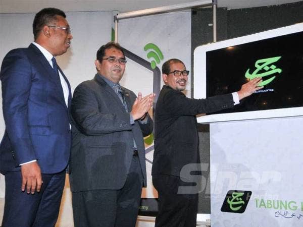 Nik Mohd Hasyudeen menyempurnakan simbolik pelancaran THiJari dan Kempen #simpandaftardanmenang sambil diperhatikan Ketua Pegawai Strategik dan Ketua Staff TH, Hizamuddin Jamaluddin serta Pengurus Besar, Simpanan dan Pengeluaran TH, Mohd Ridzuan Wahi. - Foto Rosli Talib