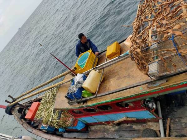 Bot nelayan Indonesia bersama lima awak-awak diperiksa selepas didapati menceroboh perairan negara. - Foto APMM Perak
