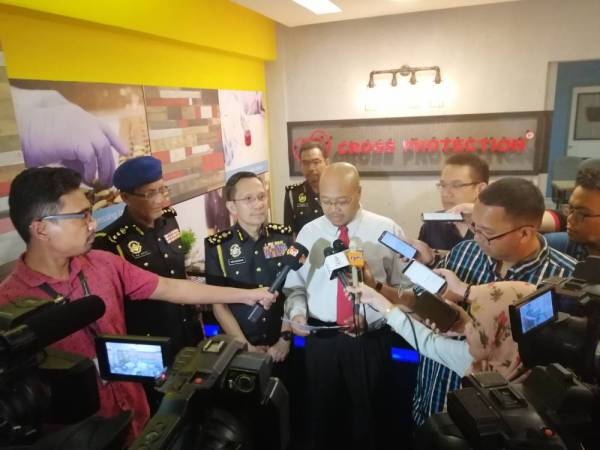 Alauddin (baju putih) dan Iskandar Halim (tiga dari kiri) ketika ditemui pemberita dalam lawatan di sebuah kilang pembuatan topeng muka Cross Protection di Klang hari ini.