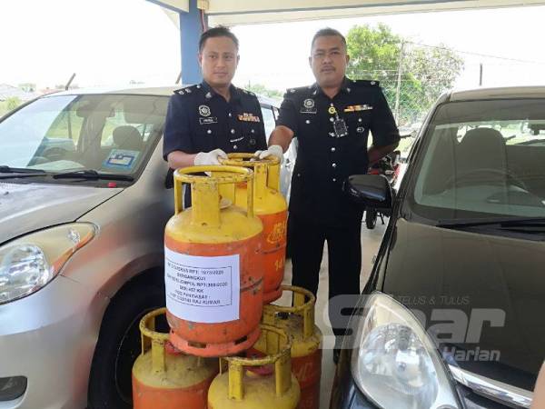 Mohd Khairiel (Kiri) menunjukkan tong gas yang dirampas selepas menahan seorang lelaki dipercayai pembeli barangan curi.