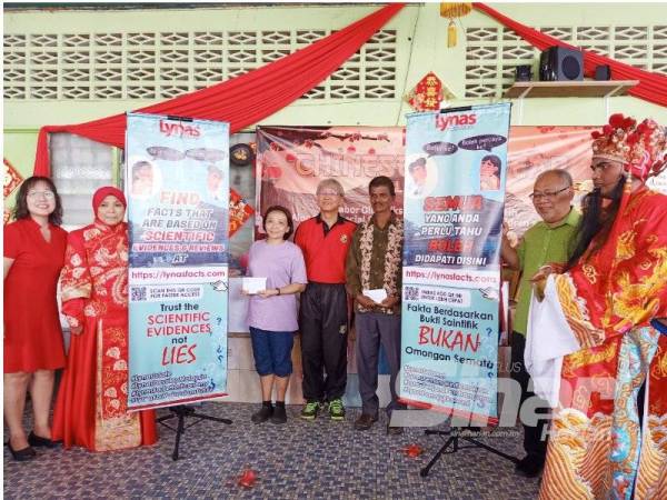 Mimi (dua dari kiri) melancarkan laman web LynasFacts.com pada majlis sambutan Tahun Baru Cina anjuran Lynas di Old Folks Home di Jabor hari ini.