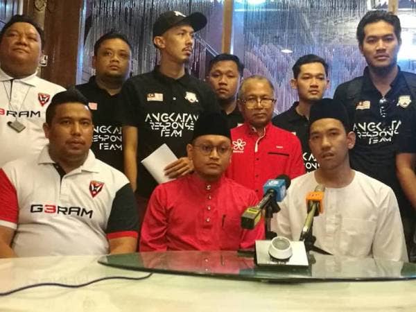 Muzzammil (duduk, kanan) ketika bercakap pada sidang media di Kelab Shah Alam di sini hari ini.