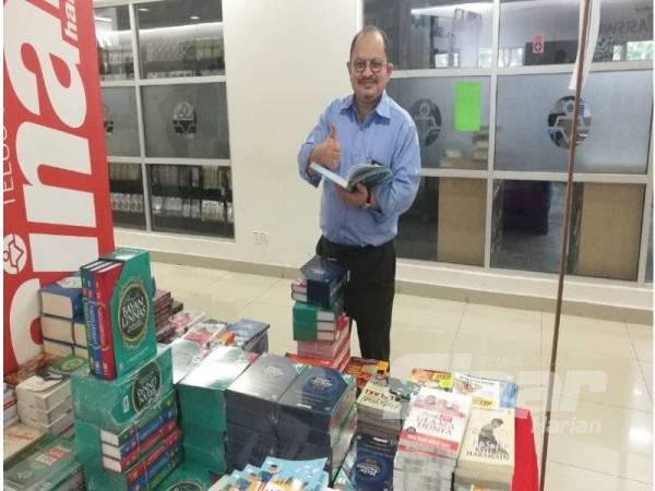 Shamsul Iskandar tidak melepaskan peluang membeli buku sempena karnival jualan gudang di Bangunan Karangkraf di sini.