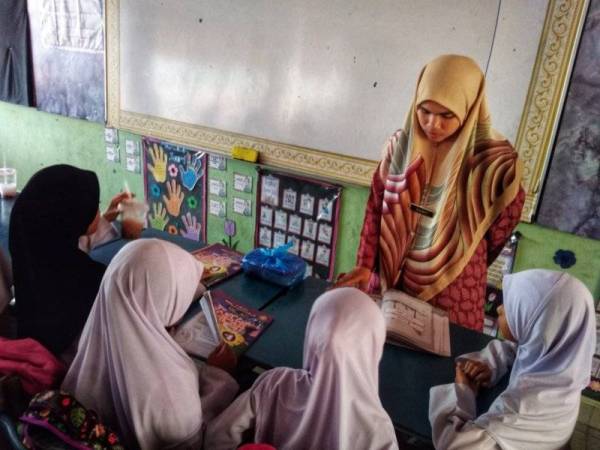 Seniwati ketika mengajar di kelas.