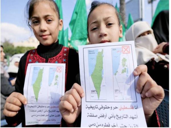 Kanak-kanak Palestin memegang gambar peta mandat British (kiri) dan peta terkini wilayah Palestin tanpa kawasan diceroboh Israel dan penempatan haram Yahudi. - Foto: Agensi