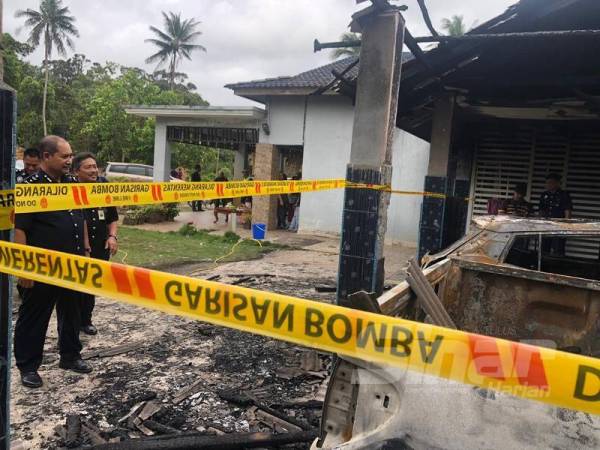 Abdullah (kiri) melihat pakir dan kereta mangsa yang hangus dalam kejadian itu. 