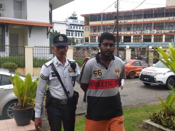 S Subasangkara diiringi seorang anggota polis trafik ketika dibawa ke mahkamah hari ini.