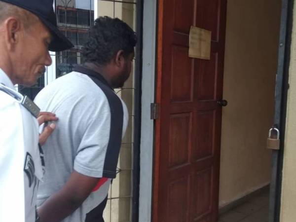 S Subasangkara diiringi seorang anggota polis trafik ketika dibawa ke mahkamah hari ini.