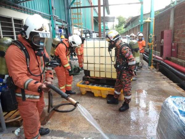 Anggota bomba melakukan kerja-kerja pembersihan kilang yang mengalami kebocoran gas di Kluang petang tadi.