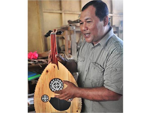 HALIDAN menunjukkan gambus yang diperbuat menggunakan kayu-kayan tempatan seperti rengas, merawan dan kayu daripada pohon buah-buahan seperti durian belanda dan ciku.
