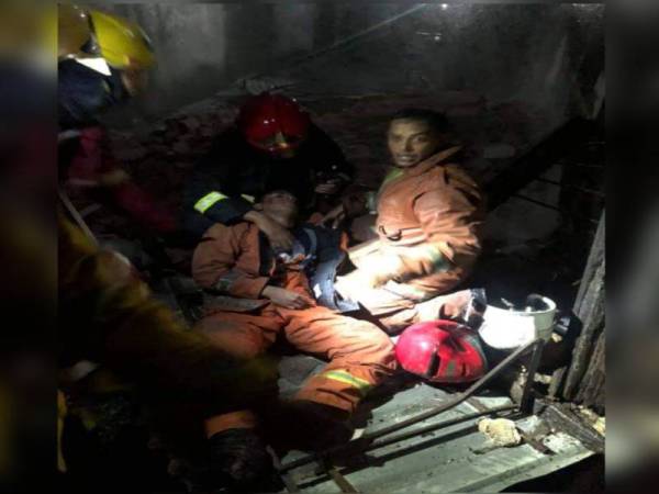 Salah seorang anggota bomba diberi bantuan selepas cedera dihempap dinding ketika operasi pemadaman api.