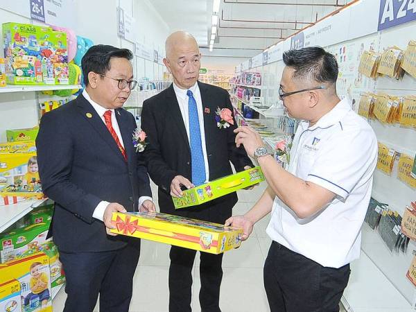 Dari kiri: Tuck Chee, Seng Kok dan T C Oh melihat produk mainan selepas merasmikan pembukaan Bilik Pameran Produk Bayi dan Mainan GM Malaysia di Klang semalam.