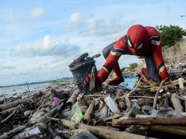 Hartono memakai kostum Spiderman bagi memupuk orang ramai untuk mengutip sampah dan menjaga kebersihan kawasan sekitar. - Foto Reuters