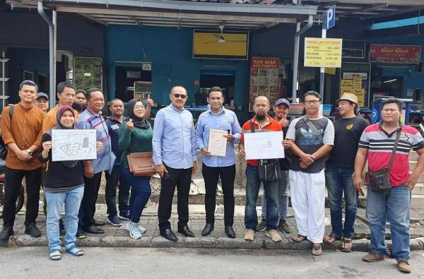 ABU Bakar (enam dari kiri) dan Mohd Ridzuan (lima dari kanan) semasa bertemu para peniaga Uptown Danau Kota yang tercicir di Setapak, Kuala Lumpur semalam.