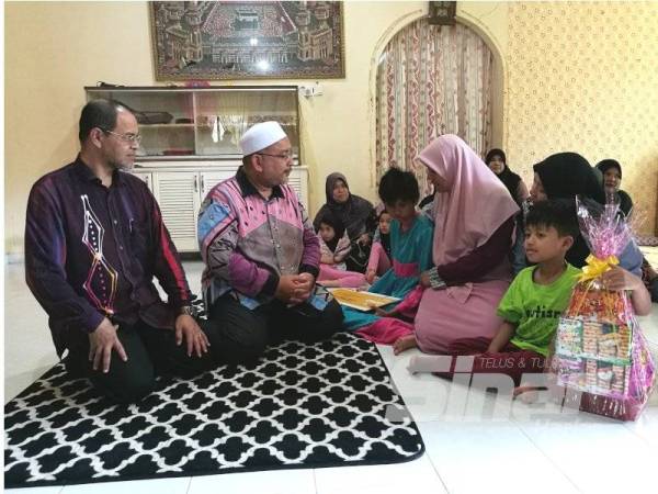 Adun Wakaf Mempelam, Wan Sukairi Wan Abdullah (dua kiri) dan Exco Kerajaan Negeri, Mohd Nurkhuzaini Ab. Rahman (kiri) ketika mengunjungi waris mangsa di Kampung Pulau Rusa hari ini.