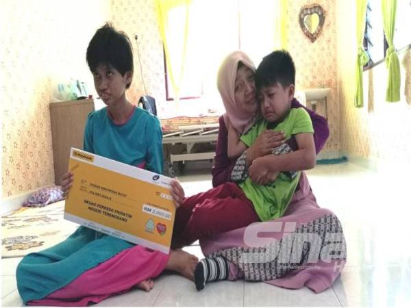 Fadhlina bersama dua anaknya, Nurul Nabila dan Muhammad Zulkarnain ketika ditemui di Kampung Pulau Rusa hari ini.