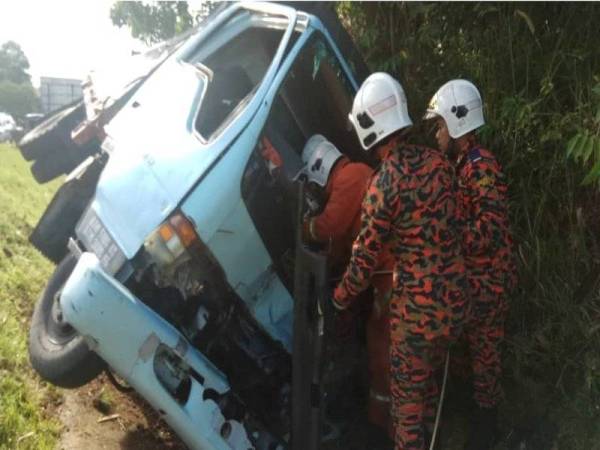 Anggota bomba mengeluarkan mangsa yang tersepit di dalam lori terbabit.