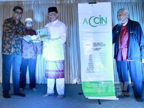 Anwar menerima cenderahati daripada Ir Mohd Jamaludin (kiri) pada Majlis Malam Anugerah Gabungan NGO Islam ACCIN di Masjid Saidina Umar al-Khattab, Bukit Damansara. - FOTO ZAHID IZZANI