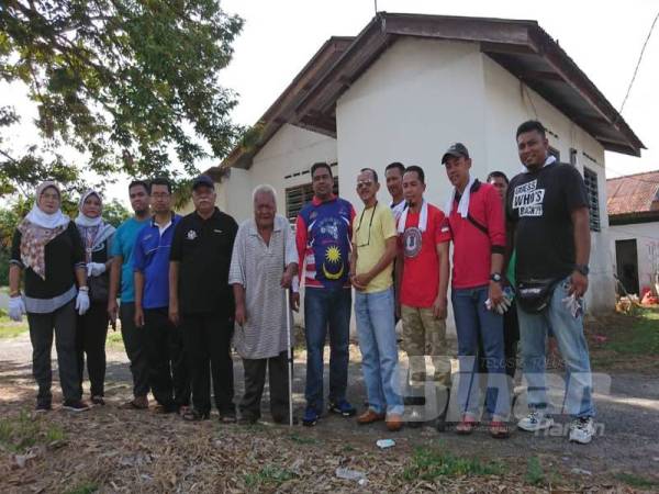 Mas Dali (enam dari kiri) bersama sebahagian ahli Bersatu yang membantu membersihkan rumahnya di Kampungku Sayang Bukit Baru, di sini, hari ini.